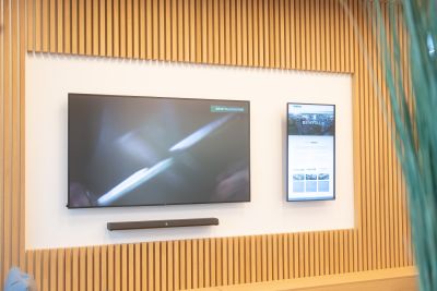 Die repräsentative Wartezone im Eingangsbereich beeindruckt Besucher:innen mit einer integrierten Videowand